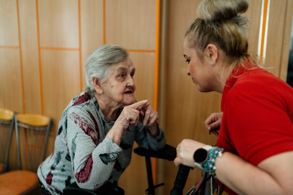 Caregiver having a warm conversation with an elderly woman