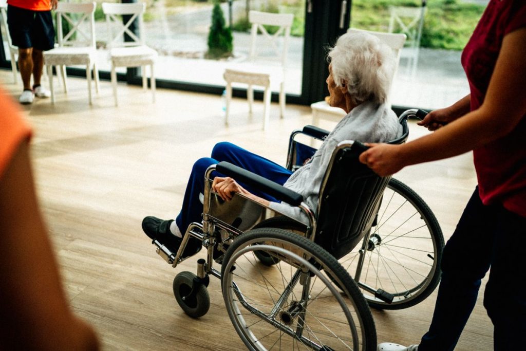 Caregiver with elderly woman comparing memory care and in-home care options