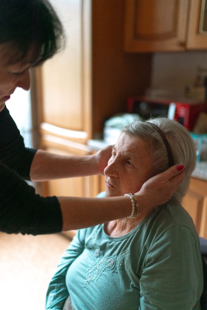 caregiver calmly comforting an elderly woman at home