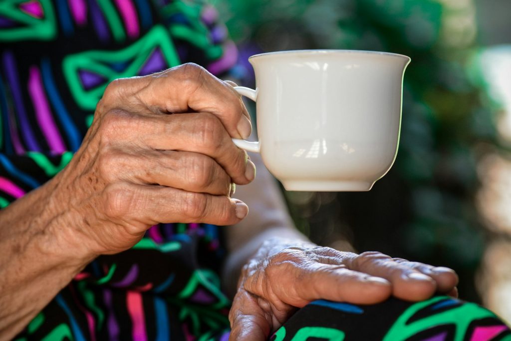 Signs your loved one may need a dementia companion: an older woman enjoying tea with a caregiver