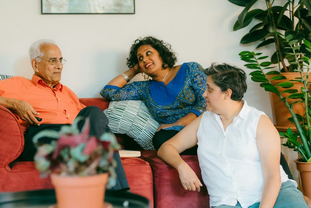 A daughter making notes while she and her father compare dementia care options at home
