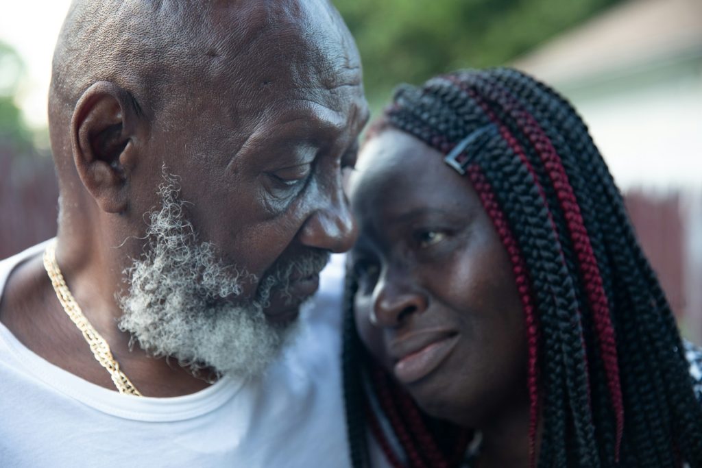 Delirium in dementia: an adult daughter sitting close to her confused older father at home