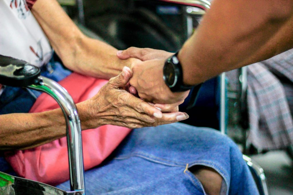 Comfort during hospice: a companion playing soft music for an older woman resting at home