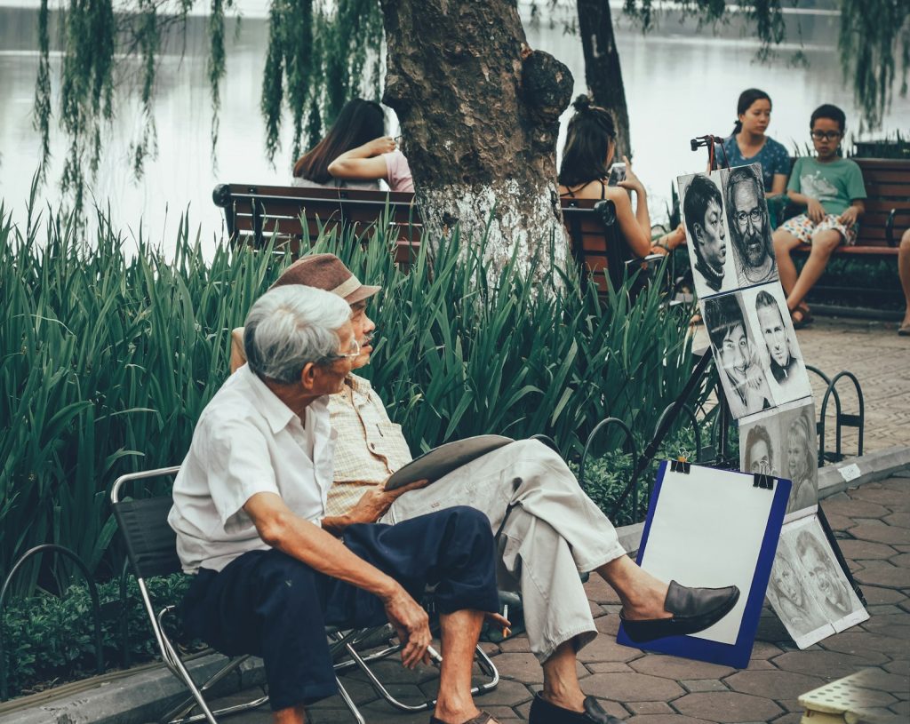 Two older men resting on a bench outdoors, a quiet outing during dementia home care in Coral Springs