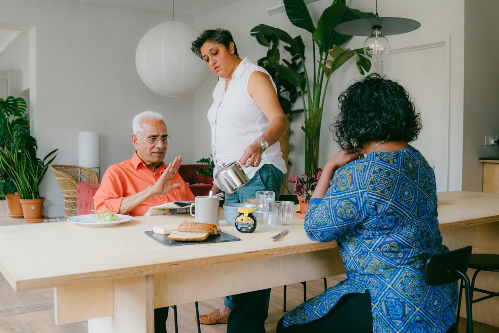 Family and friends sharing a meal around the table, the routine dementia home care in Lehigh Acres helps protect