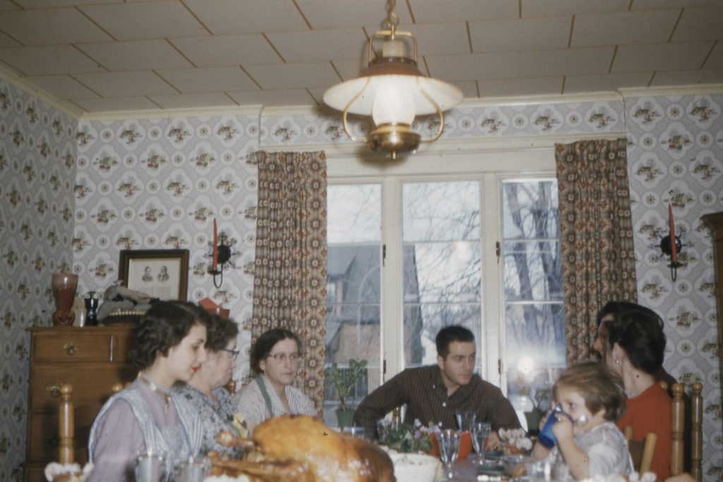 A quiet holiday moment as a daughter and her mother look through an old photo album