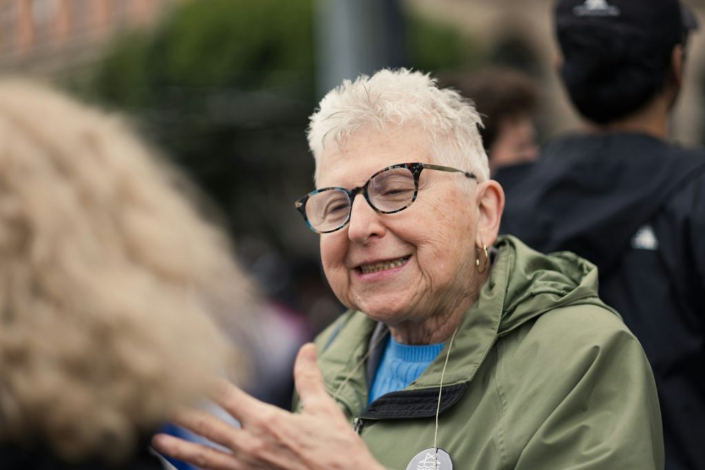 A companion sitting at eye level, showing how to talk to someone with dementia using a photo album