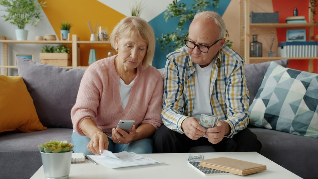 A family organizing legal papers about guardianship of a parent with dementia at the kitchen table