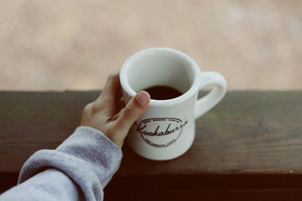 Self-care for dementia caregivers: a woman taking a quiet coffee break on a sunny porch