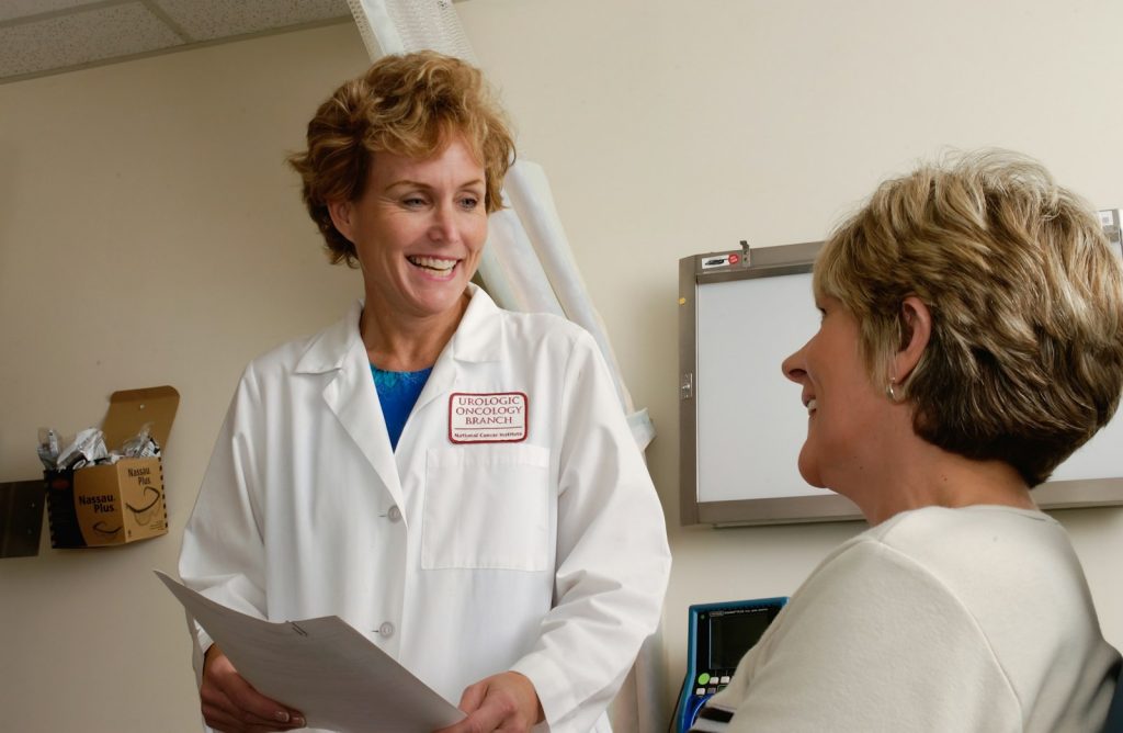 A caregiver holding a written list of questions before doctor visits with her mother who has dementia