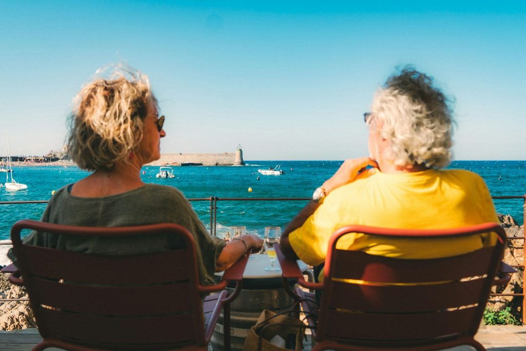 A companion providing dementia home care in Aventura, cooking a familiar family recipe with an older woman