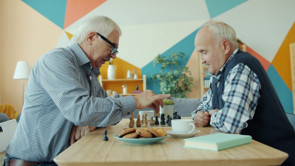 Two older men playing a table game at home, the kind of pastime dementia care in Hialeah keeps going