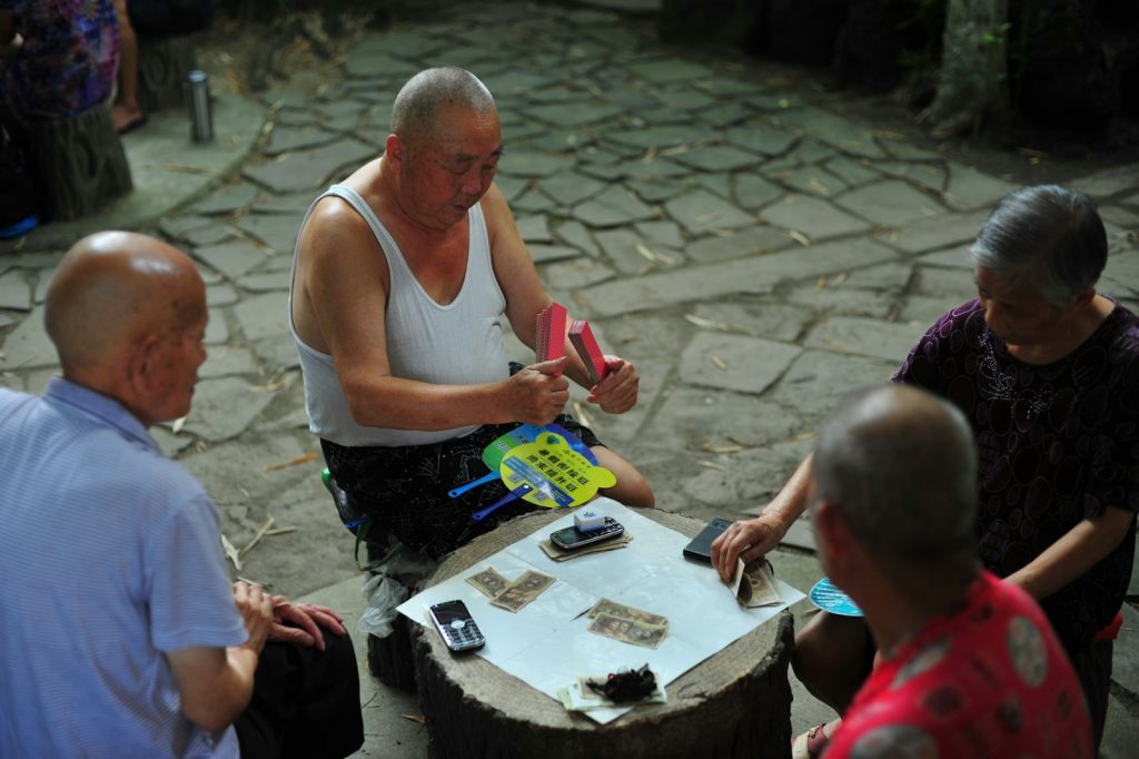 A companion providing dementia home care in Miami Lakes, reading a Spanish newspaper with an older woman