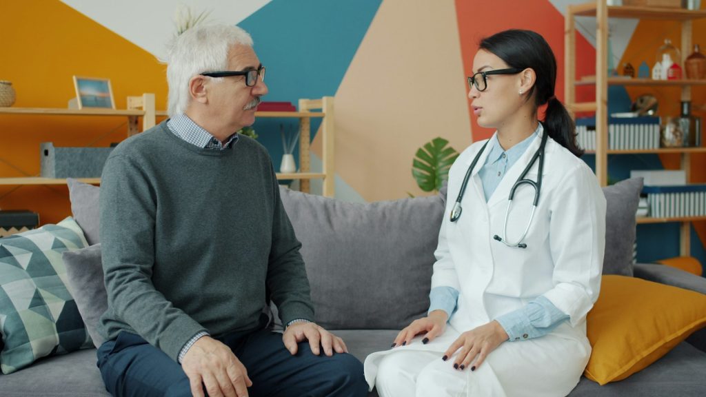 A daughter reviewing paperwork with her father as they ask: does Medicare cover dementia care at home?