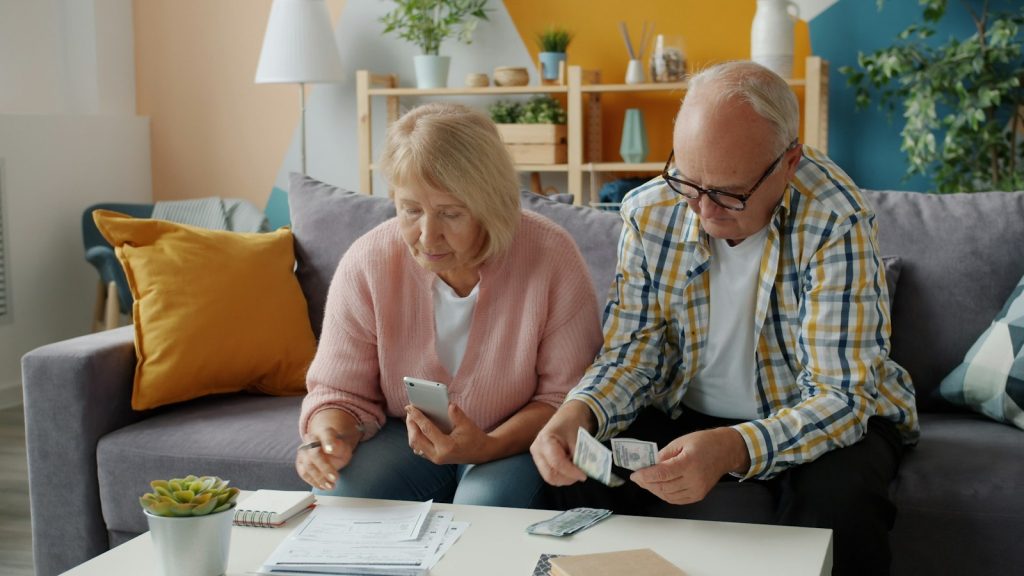 A daughter helping her father set up bank alerts to prevent financial exploitation