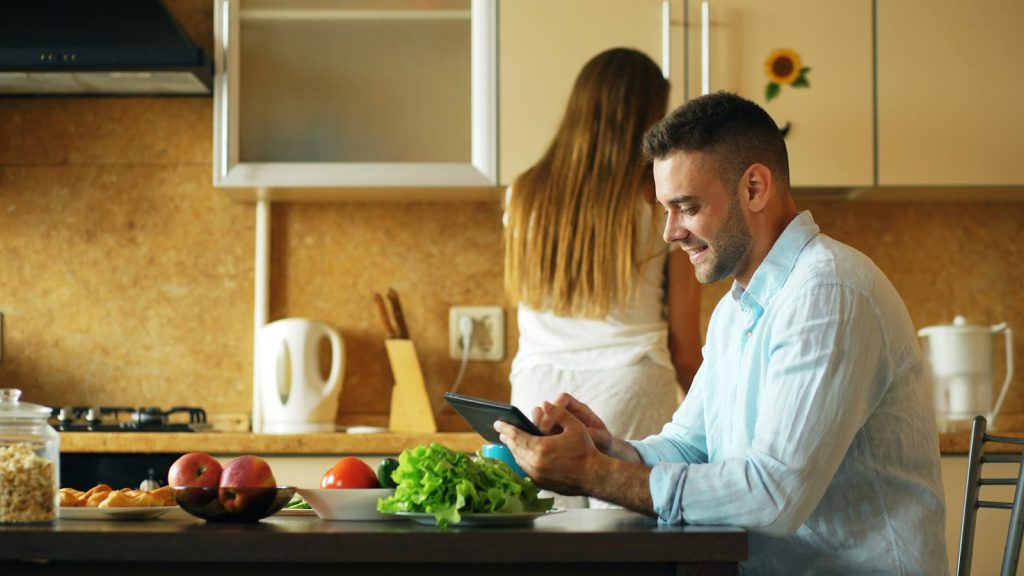 Planning with a dementia care cost calculator: a daughter comparing in-home care costs on a laptop with her father