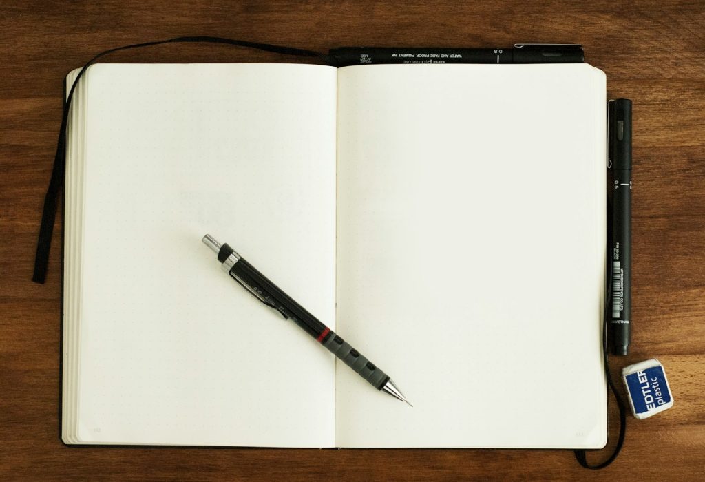 Filling in a dementia care log: a companion writing visit notes while an older woman rests nearby