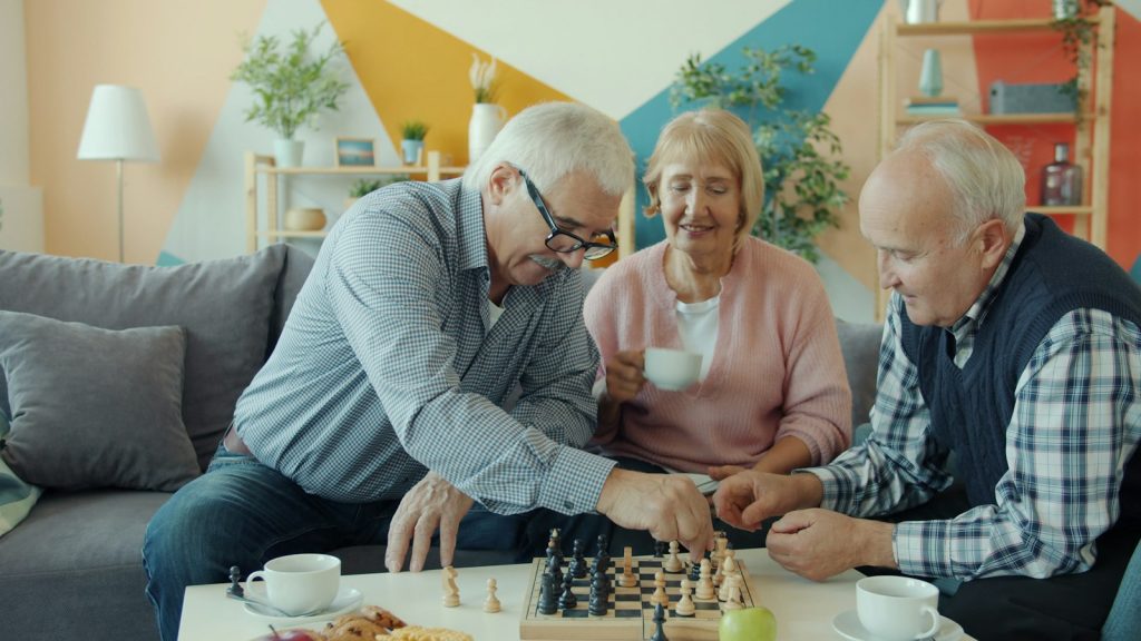 Dysphagia and dementia: an older woman sitting upright and sipping a drink slowly at the table